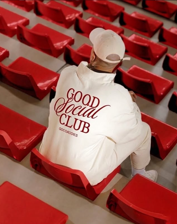 Good Social Club member wearing branded apparel among red stadium seats